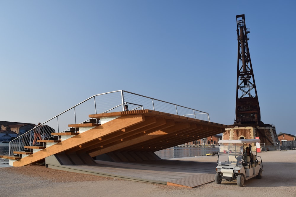 a man driving a fork lift next to a wooden structure