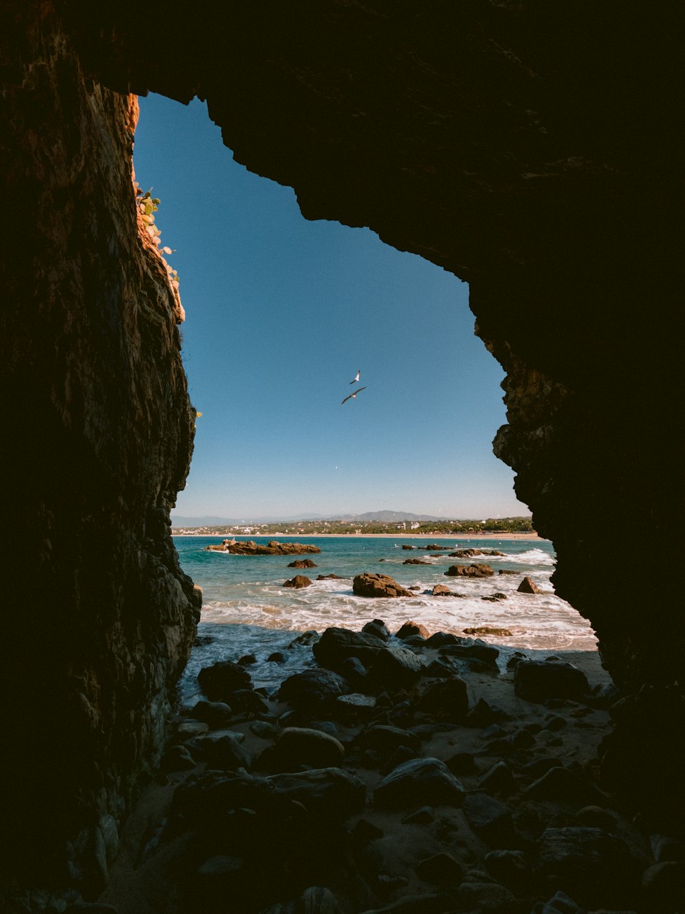 a view of the ocean through a cave