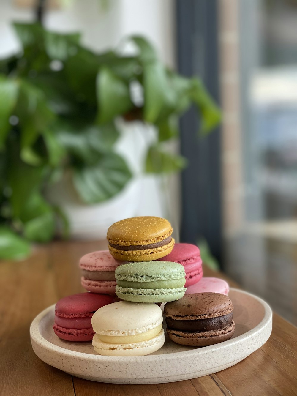 a plate of macaroons sitting on a wooden table