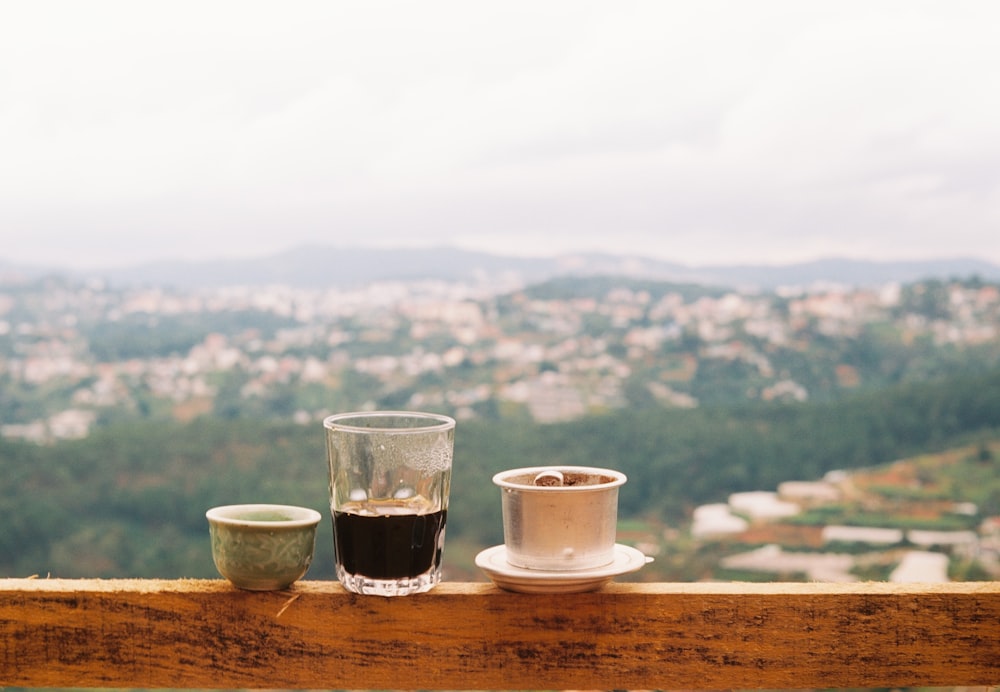 a couple of cups sitting on top of a wooden table