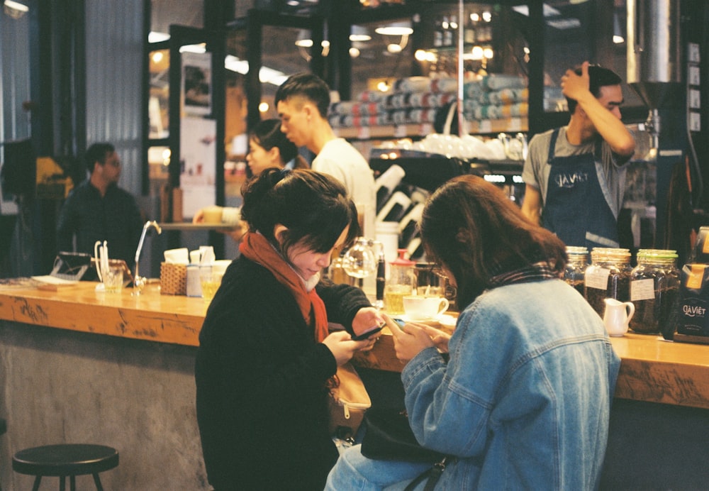 Un grupo de personas sentadas en un mostrador en un restaurante