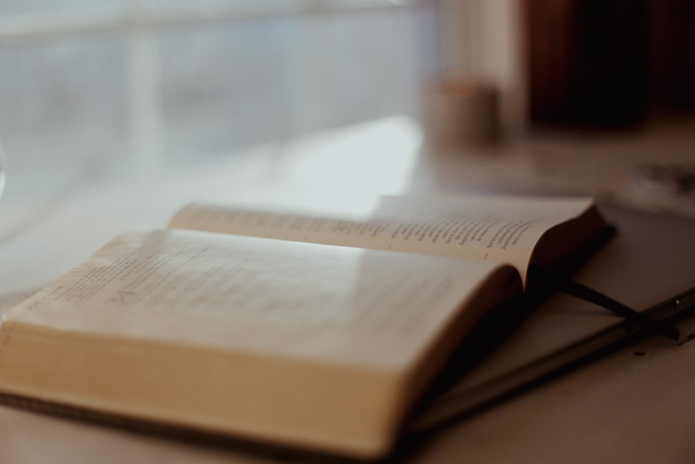 an open book sitting on top of a table next to a cup of coffee