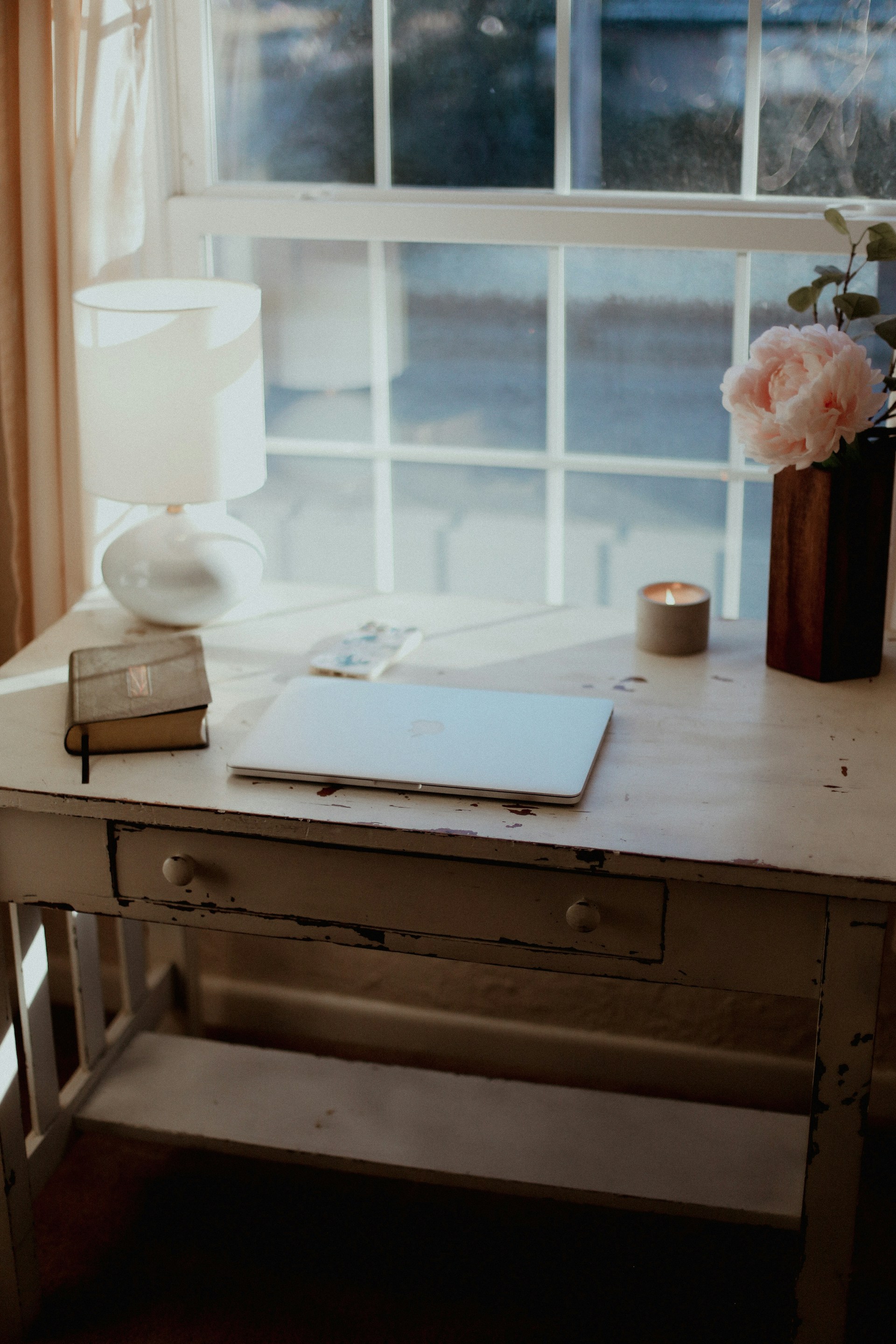 a desk with a lamp and a book on it