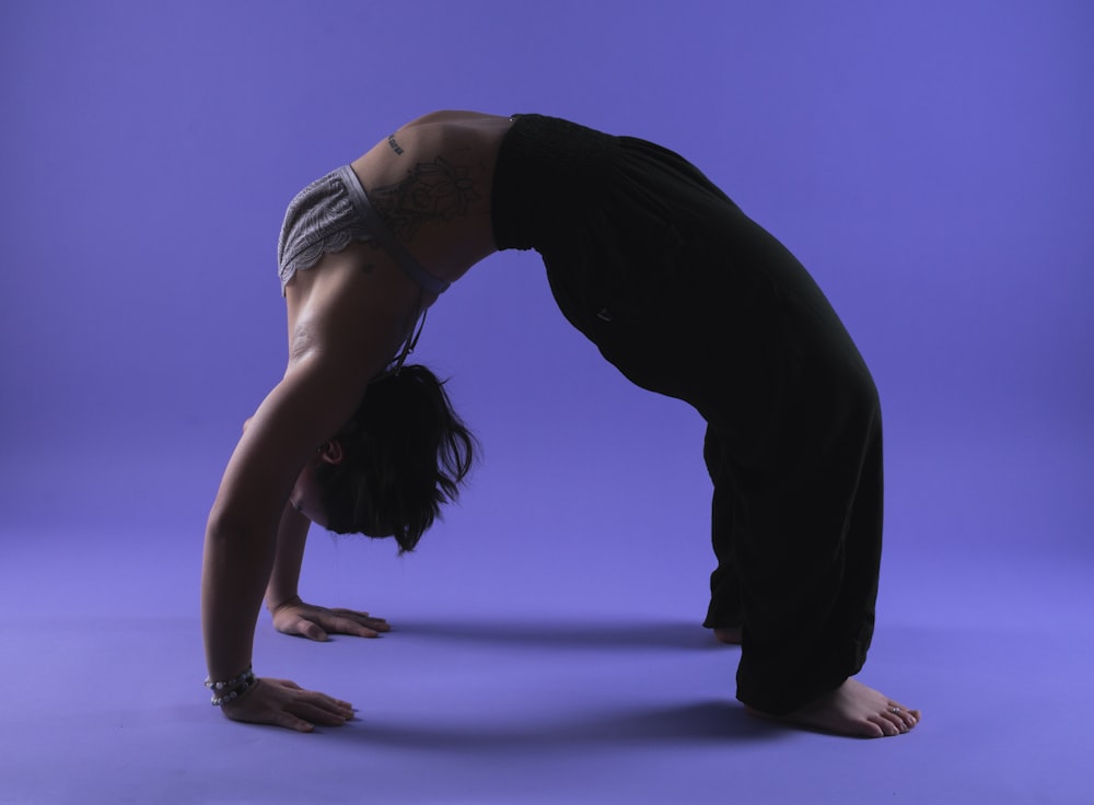 uma mulher está fazendo um handstand em um fundo azul