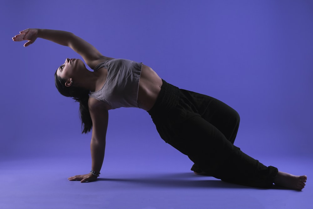 a woman is doing a yoga pose on a blue background