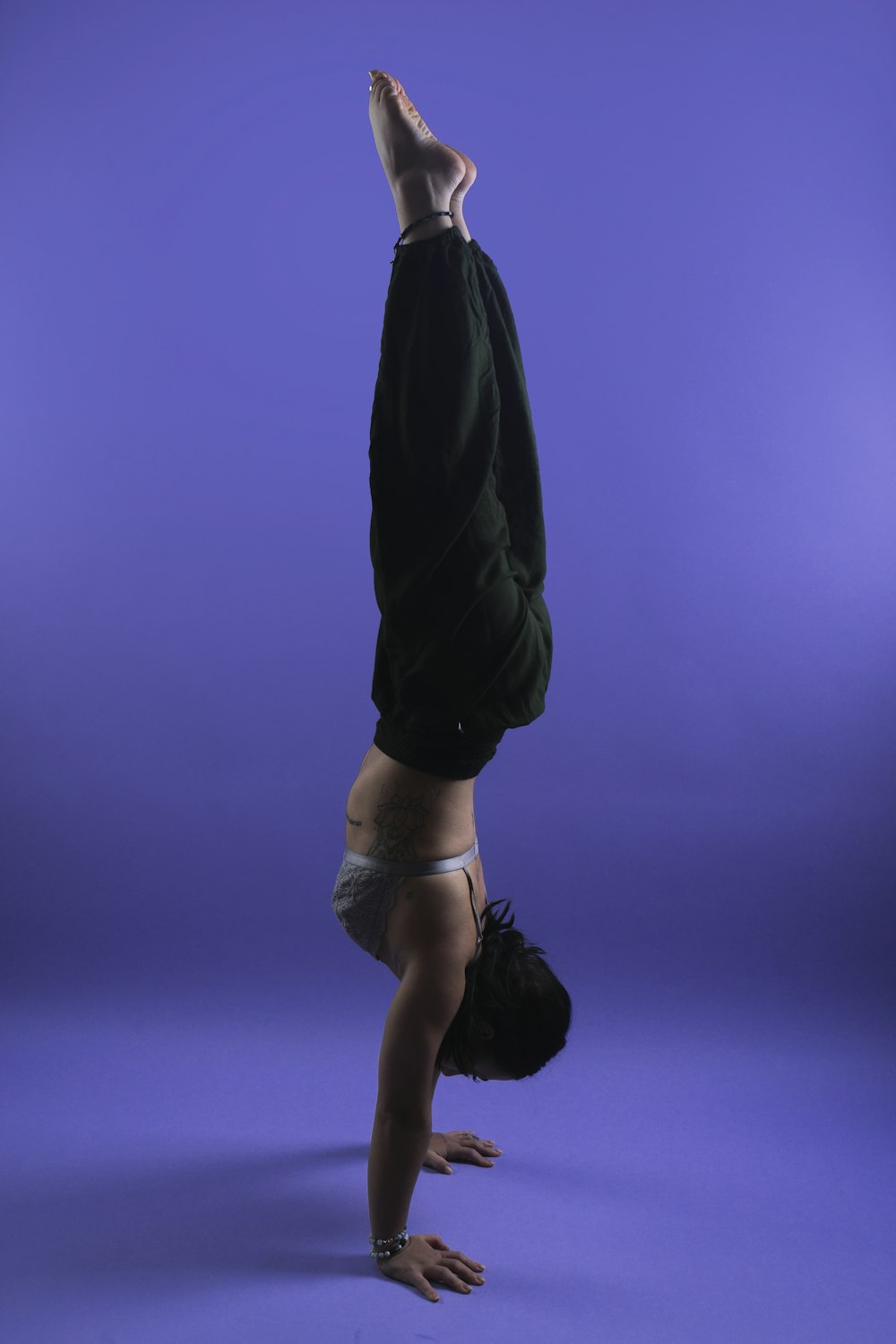 a person doing a handstand on a purple background