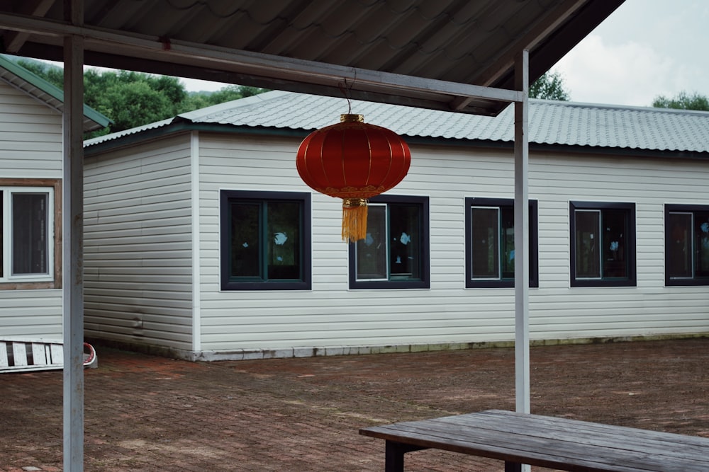 a white house with a red lantern hanging from it's roof