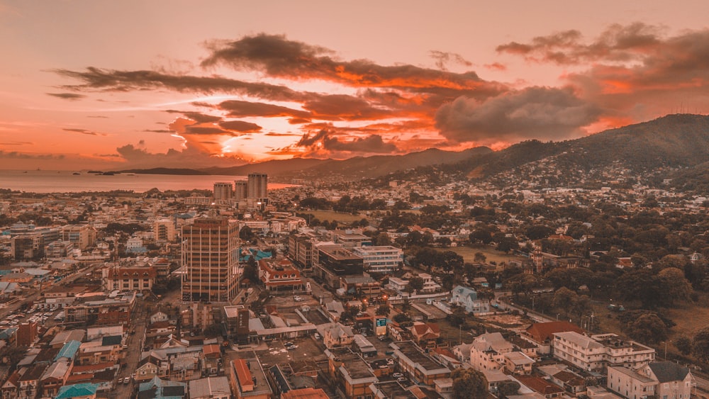 Una puesta de sol sobre una ciudad con montañas al fondo