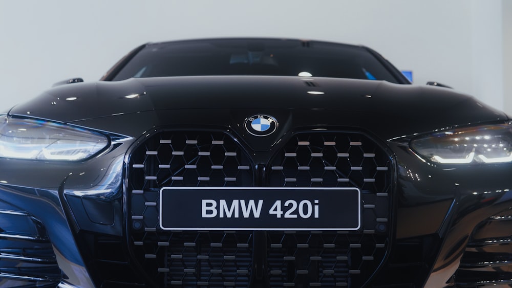 the front of a black bmw car in a showroom