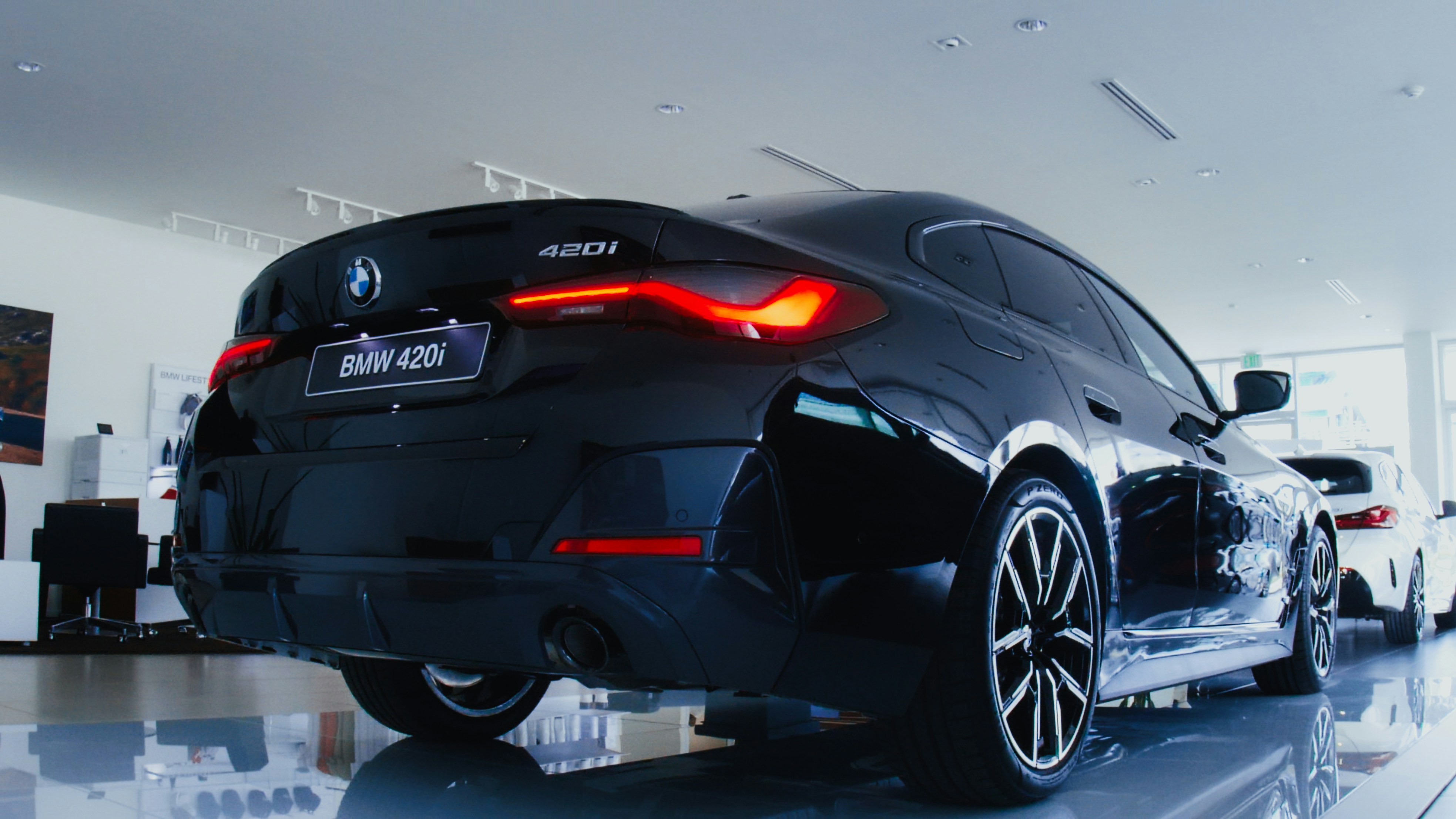 Un coche negro está aparcado en una sala de exposición