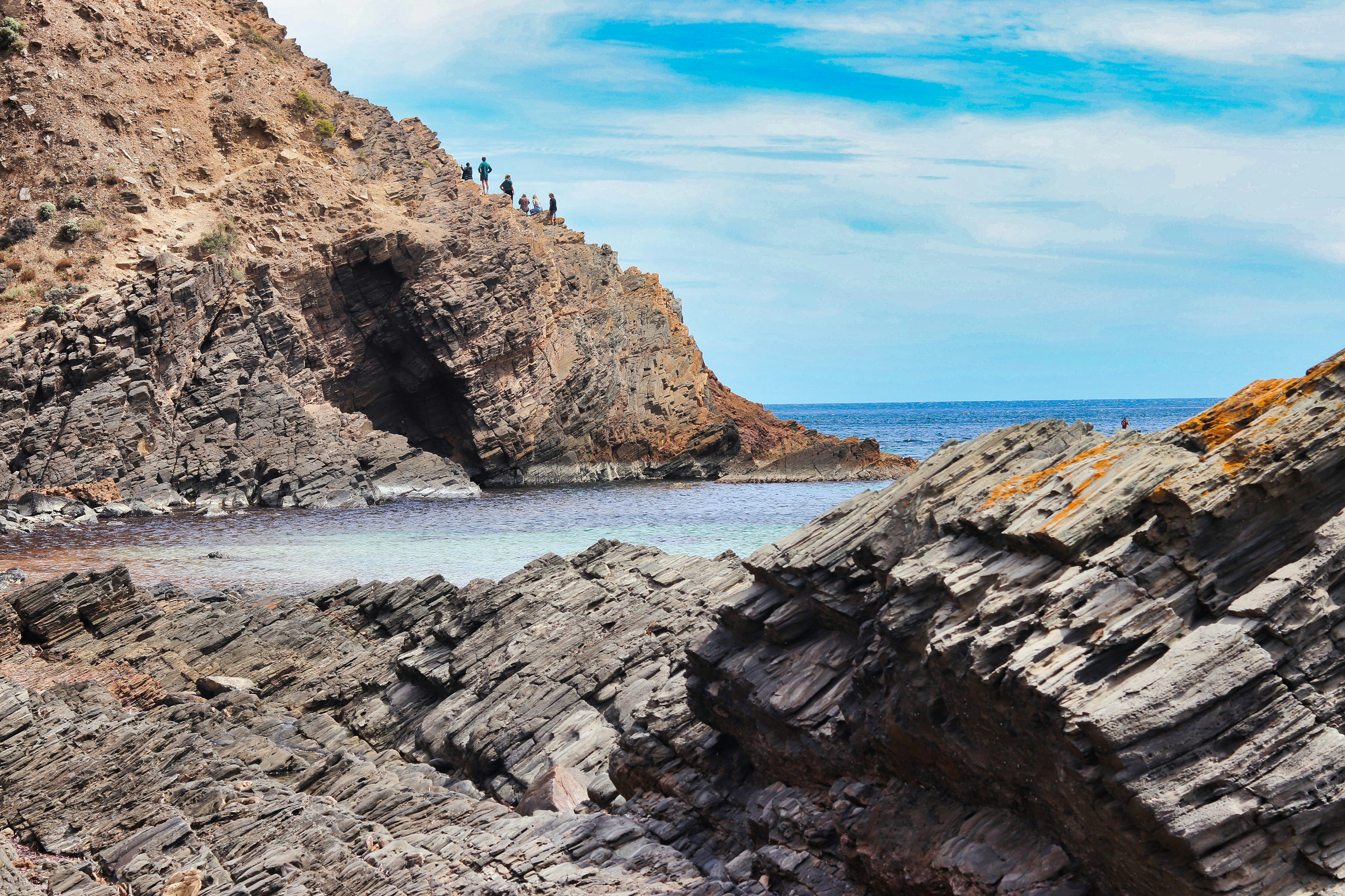 a group of people standing on top of a rocky cliff