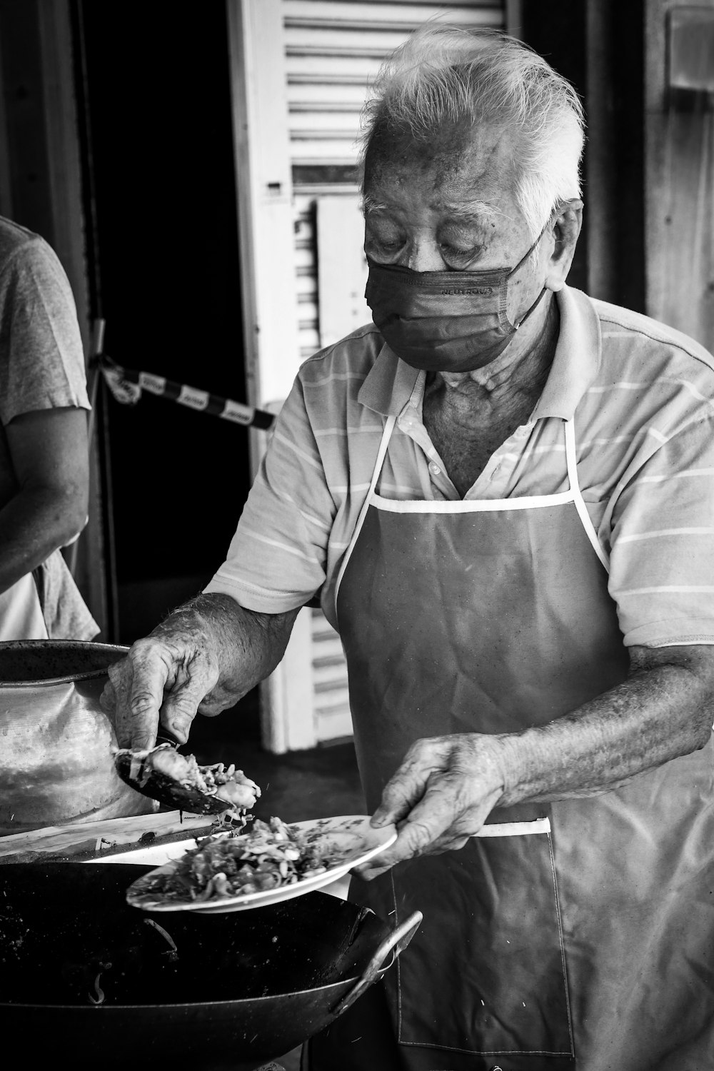 a man wearing a face mask preparing food