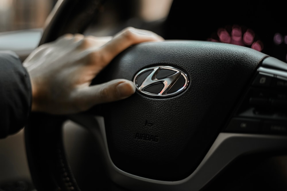 a person holding the steering wheel of a car