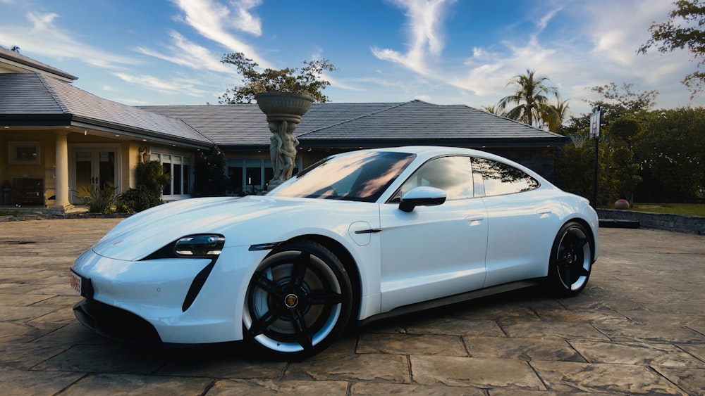 a white sports car parked in front of a house