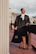 a woman in a black dress holding a blue bag