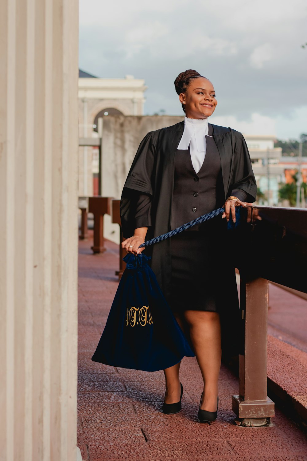 a woman in a black dress holding a blue bag