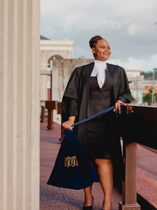 a woman in a black dress holding a blue bag