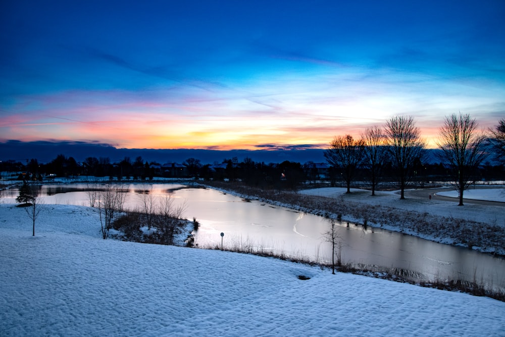 uma paisagem nevada com um rio que a atravessa