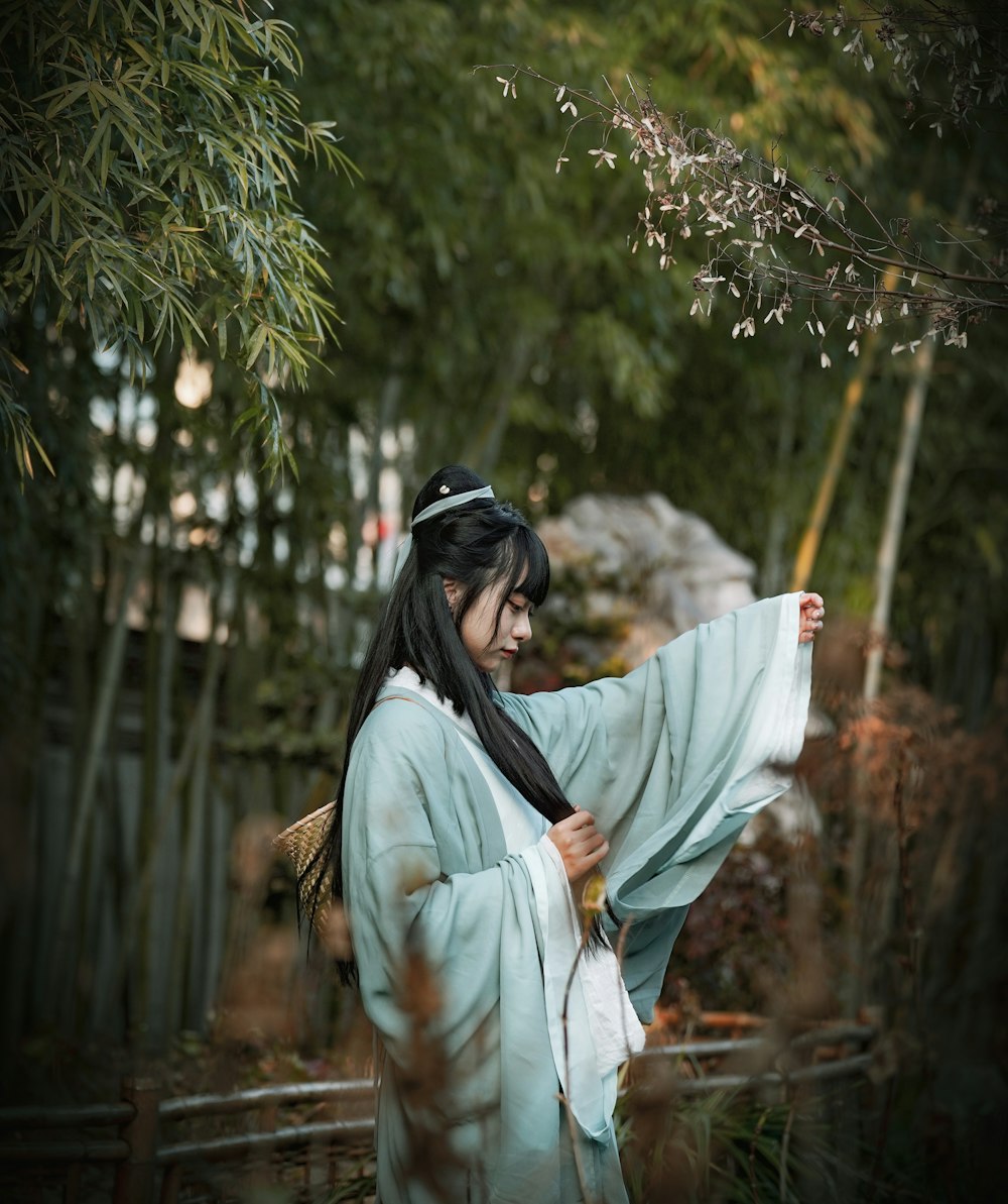 a woman in a kimono is holding a fan