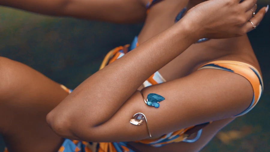 a woman in a bikini with a ring on her arm