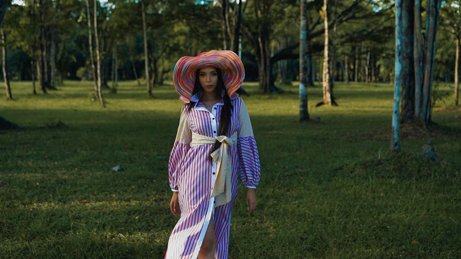 a woman in a dress and hat walking through the woods