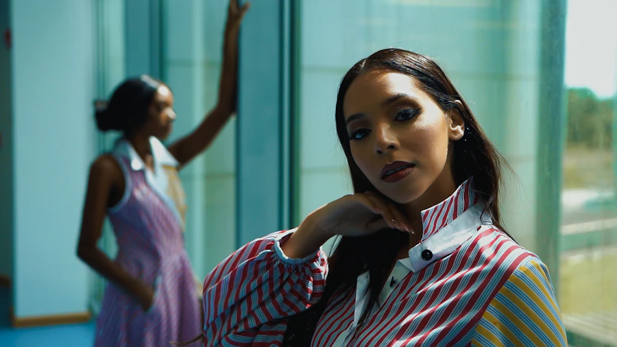 a woman in a striped shirt and tie posing for a picture
