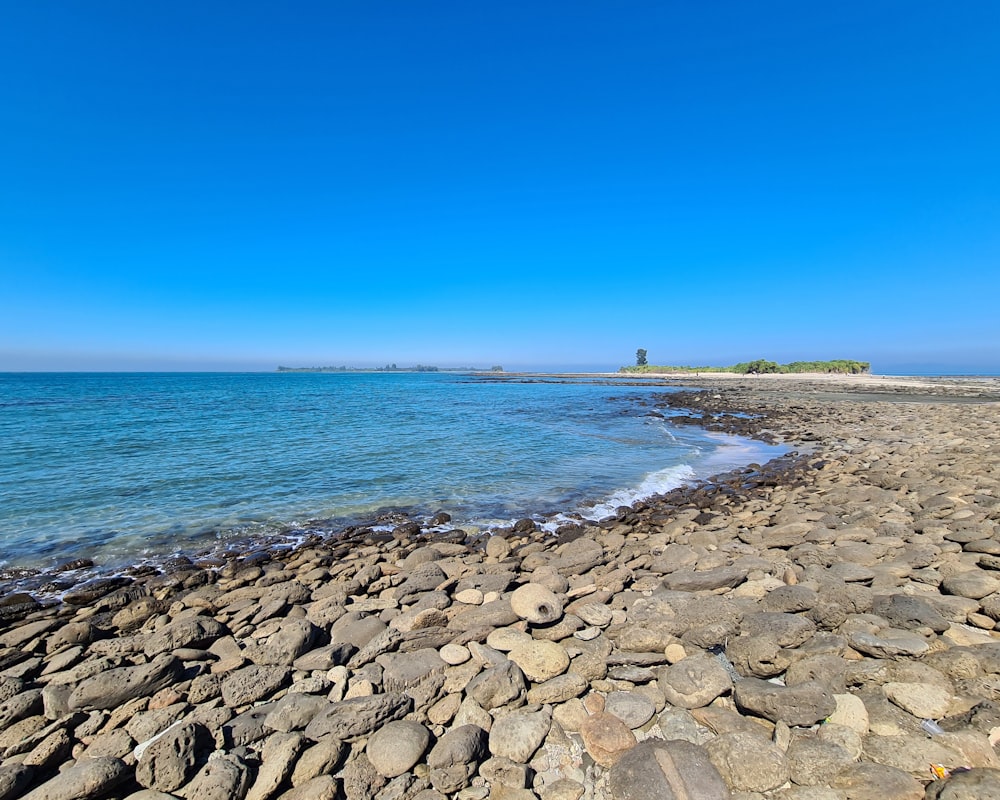 青空の下の海に面した岩場