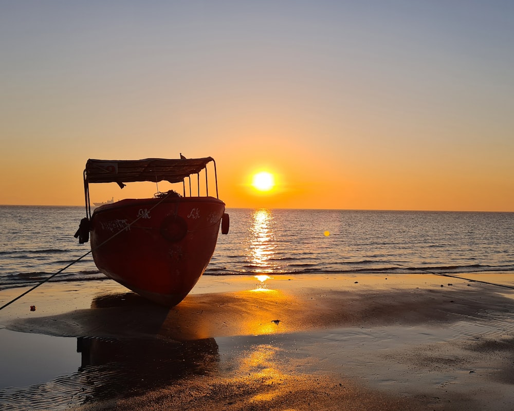 Un bateau assis au sommet d’une plage au bord de l’océan