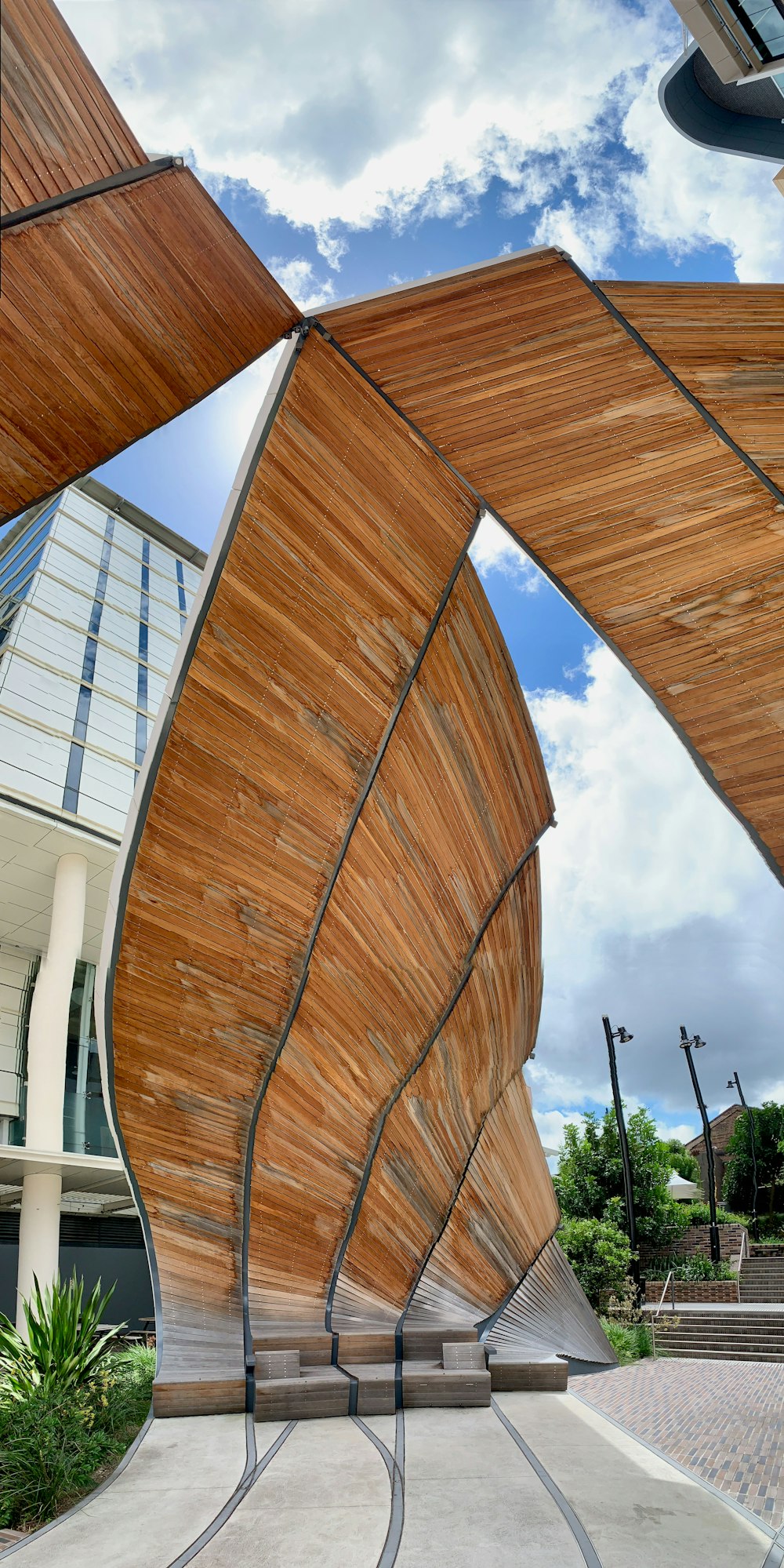 a curved wooden structure with a sky background