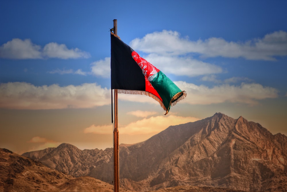 a flag on a pole with mountains in the background