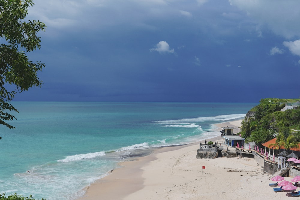 a view of a beach with umbrellas and a cloudy sky
