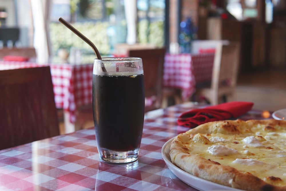 una pizza y una bebida en una mesa