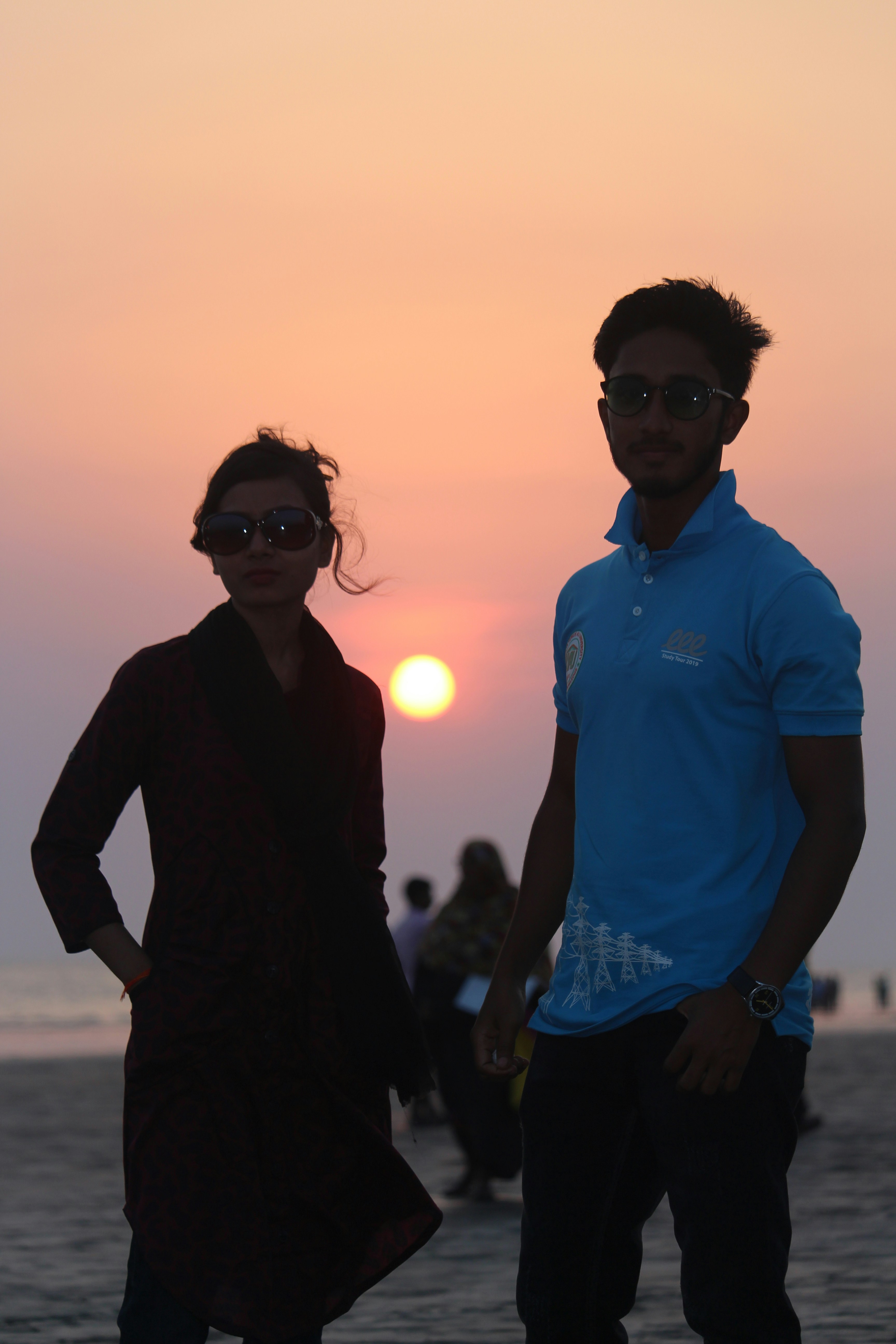 A man and a woman standing on a beach at sunset photo – Free Sky Image ...