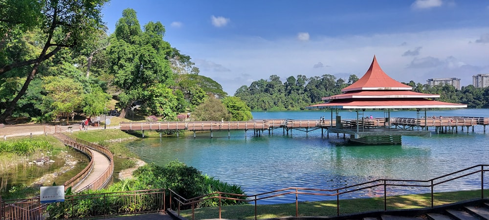 a gazebo sitting on top of a lake next to a forest