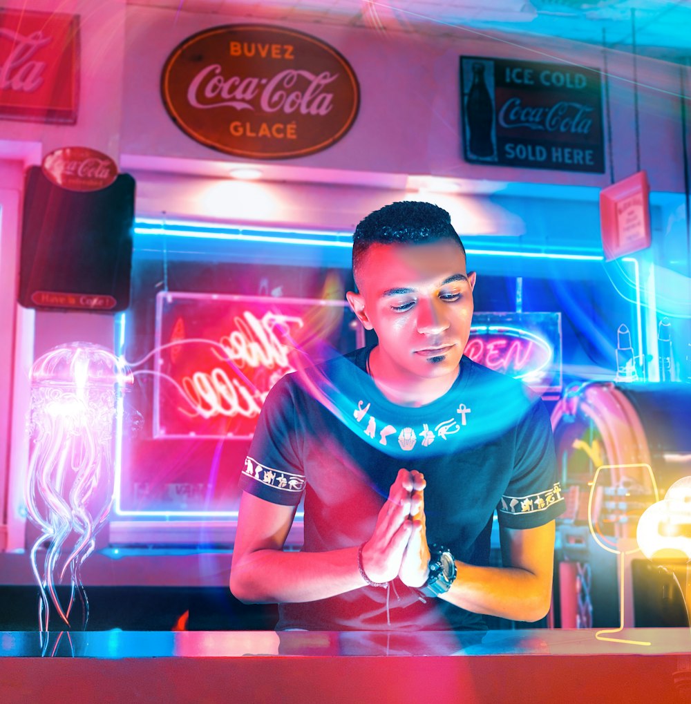 a man standing in front of a neon bar