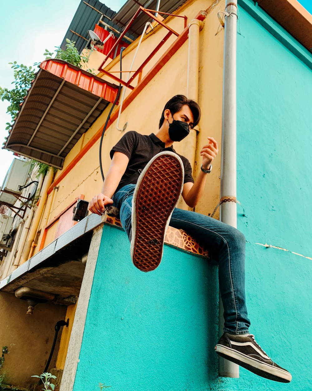 a man sitting on a ledge with a skateboard