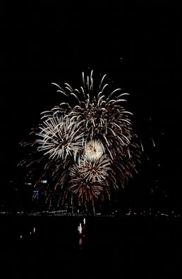 A cascade of shimmering gold and white fireworks over a cityscape.