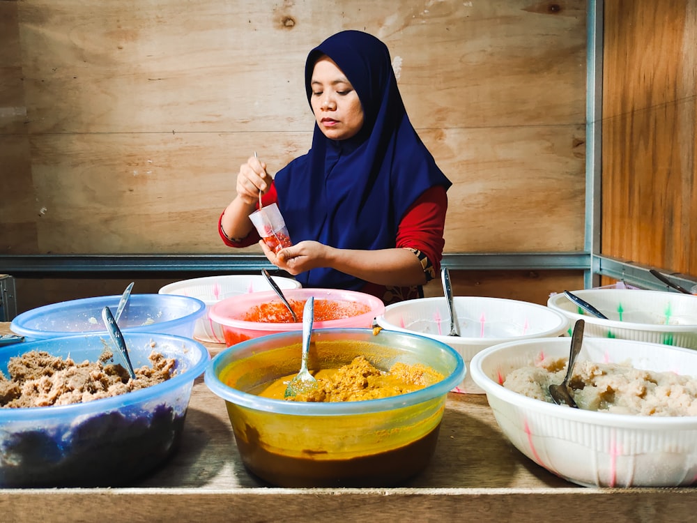 a woman standing in front of a table filled with bowls of food