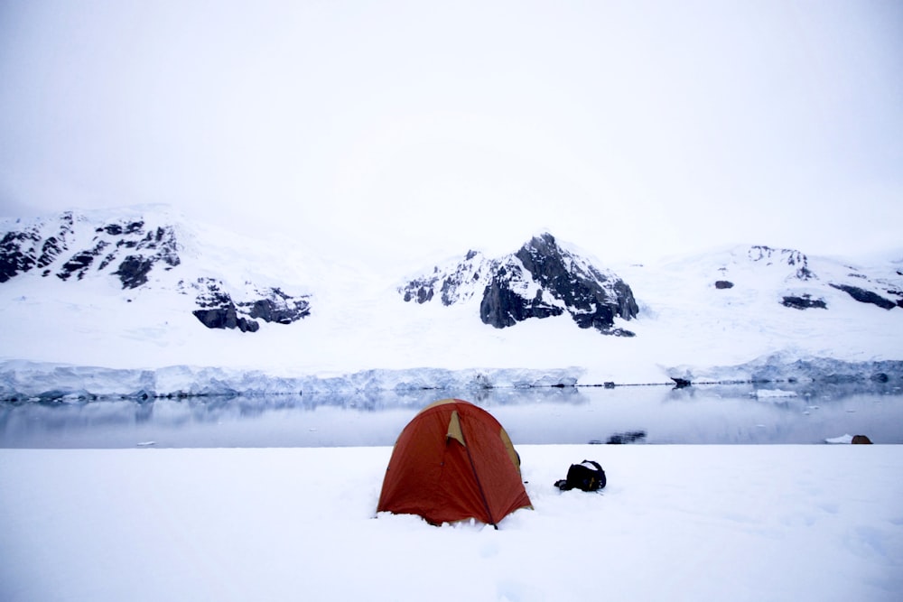 a red tent sitting on top of snow covered ground