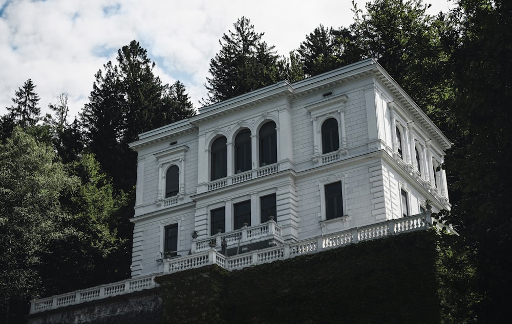 a large white house sitting on top of a lush green hillside