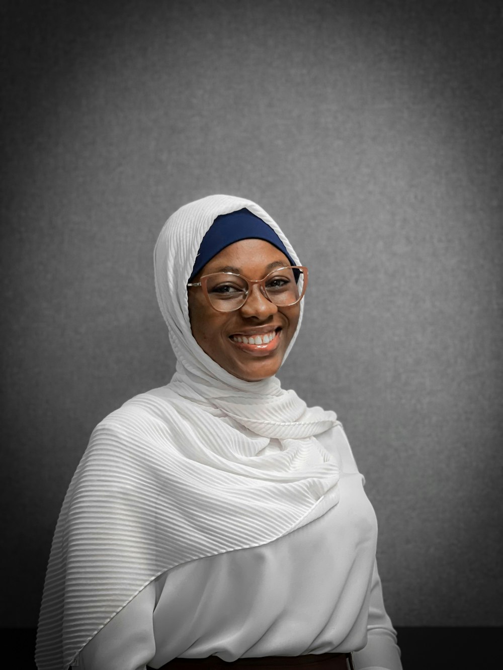 a woman wearing a headscarf and glasses