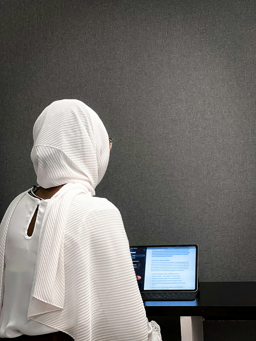 a person sitting at a desk with a laptop