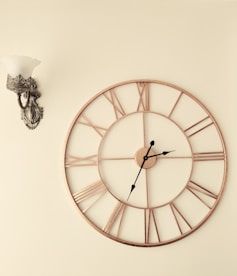 a clock on a wall next to a wall sconce