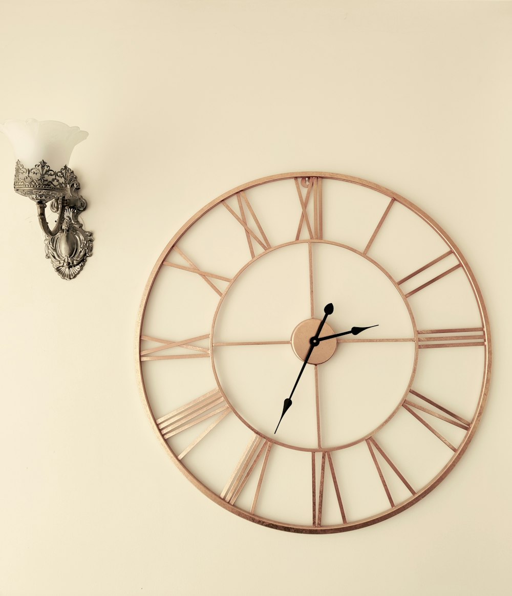 a clock on a wall next to a wall sconce