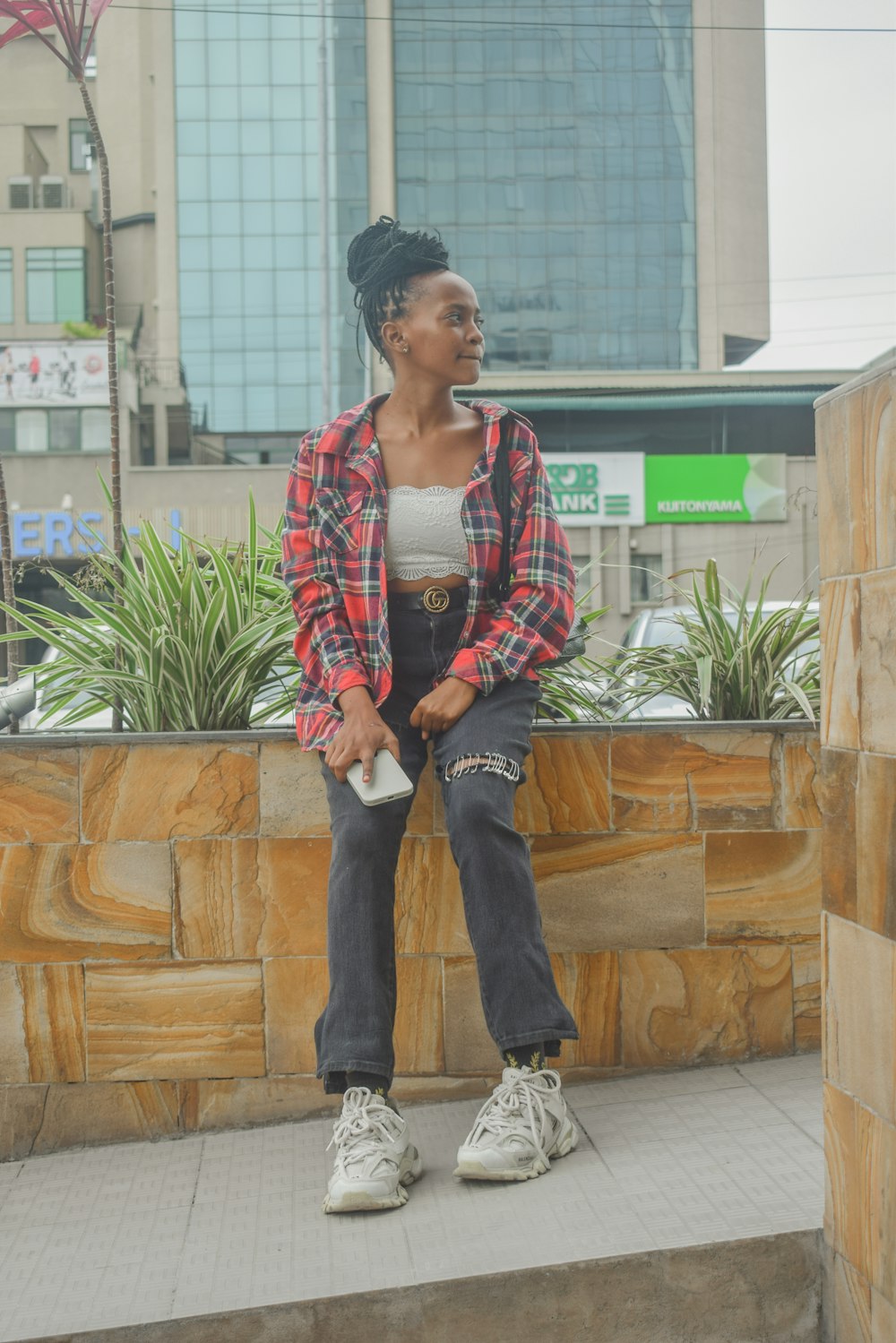 a woman sitting on a ledge in front of a building