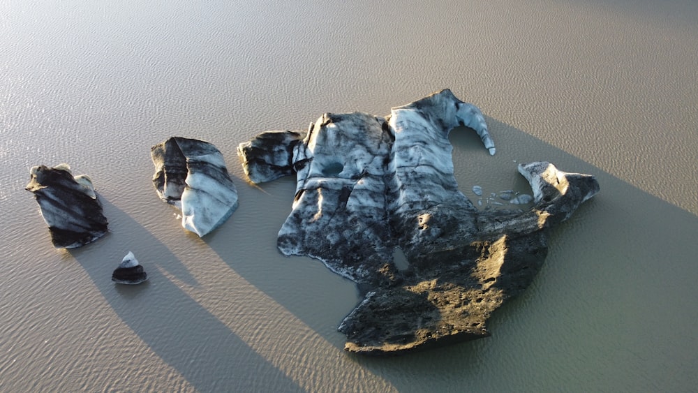 a group of rocks sitting on top of a sandy beach