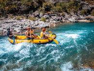 a group of people riding on the back of a raft