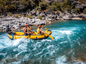a group of people riding on the back of a raft