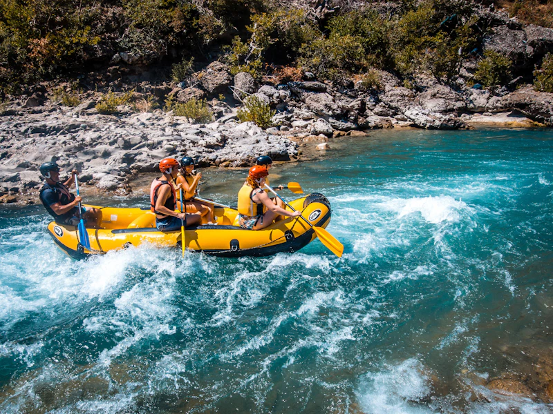 A crew of rafters paddling together, seen from behind
