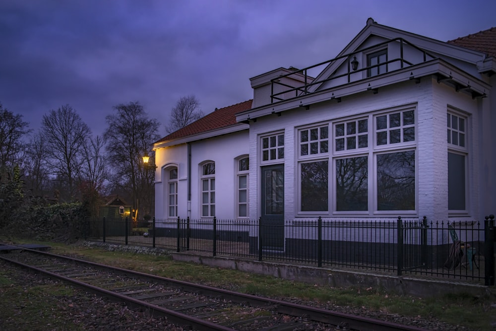 Une Maison Blanche assise à côté d’une voie ferrée